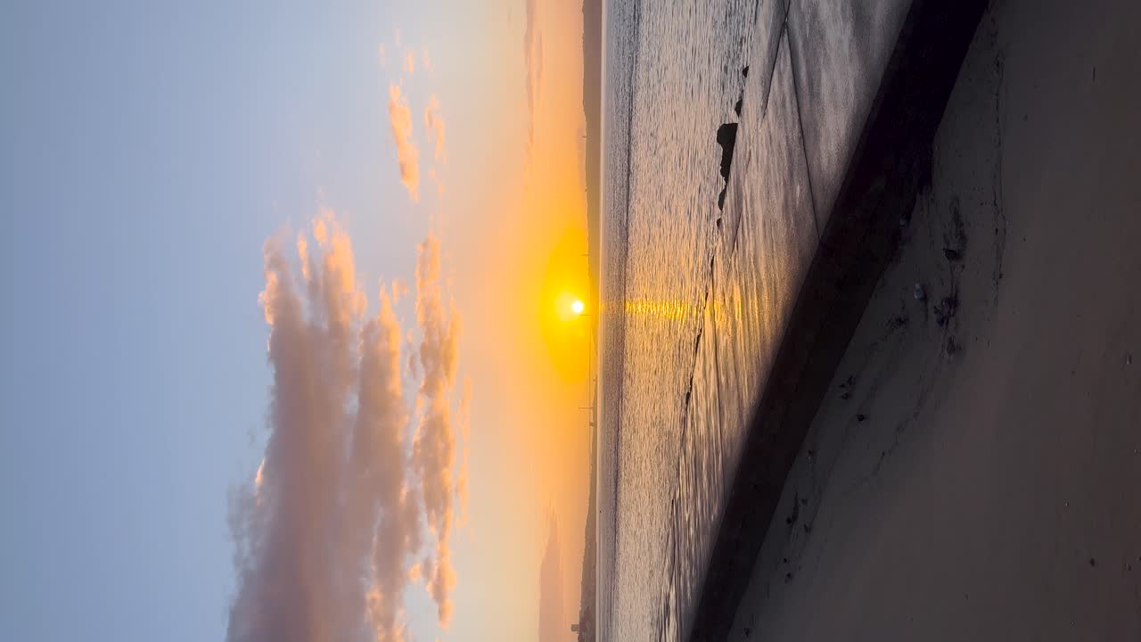 Sunset sunrise over ocean sea water calm sandy beach shore, sun reflection