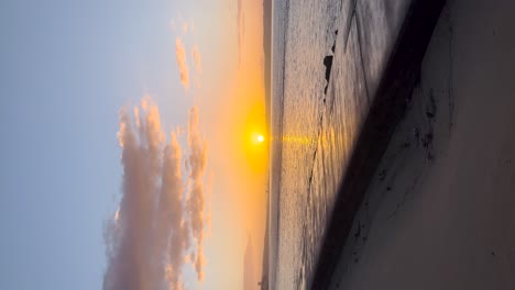 sunset sunrise over ocean sea water calm sandy beach shore, sun reflection