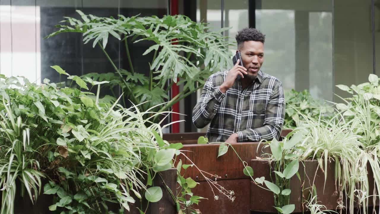 행복 한 아프리카계 미국인 남성 창의적 인 스마트 폰에서 캐주얼 사무실에서 슬로우 모션으로 이야기