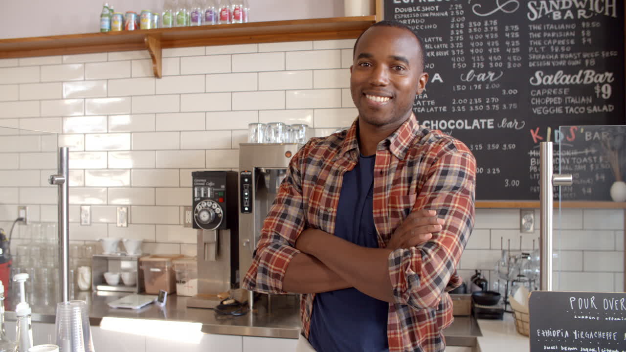 Business owner crosses arms at the counter of coffee shop