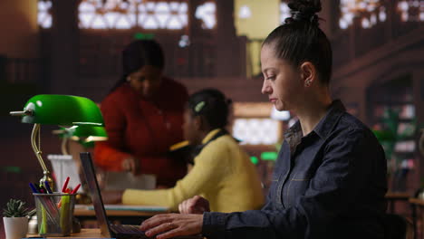 women working on laptops in a library