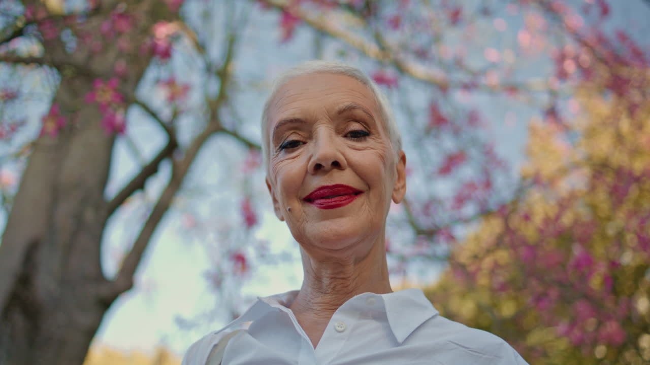 Portrait  pensioner park bottom view. Smiling calm lady looking camera