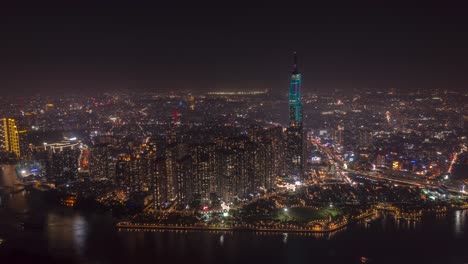 night hyperlapse of city and landmark skyscraper on waterfront from aerial view