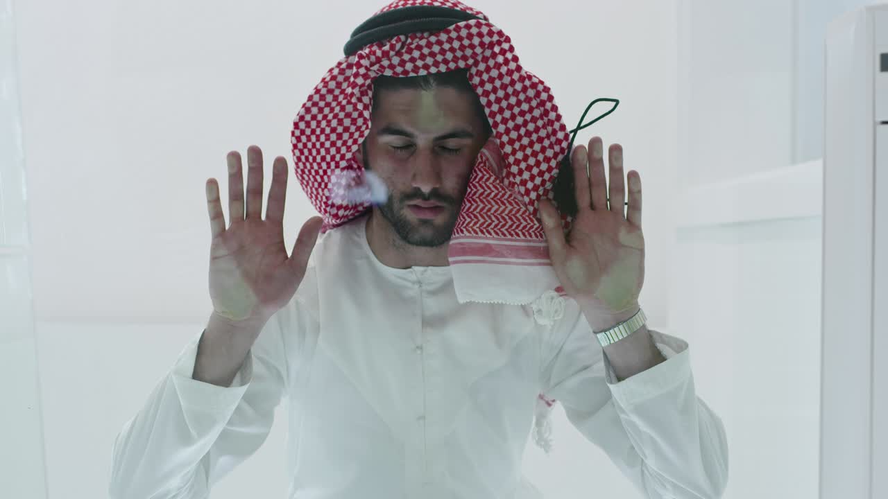 hombre musulmán con ropa tradicional orando en el piso de vidrio antes de la cena de iftar