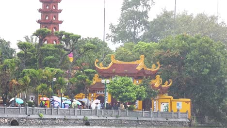 people with umbrellas at tran quoc pagoda