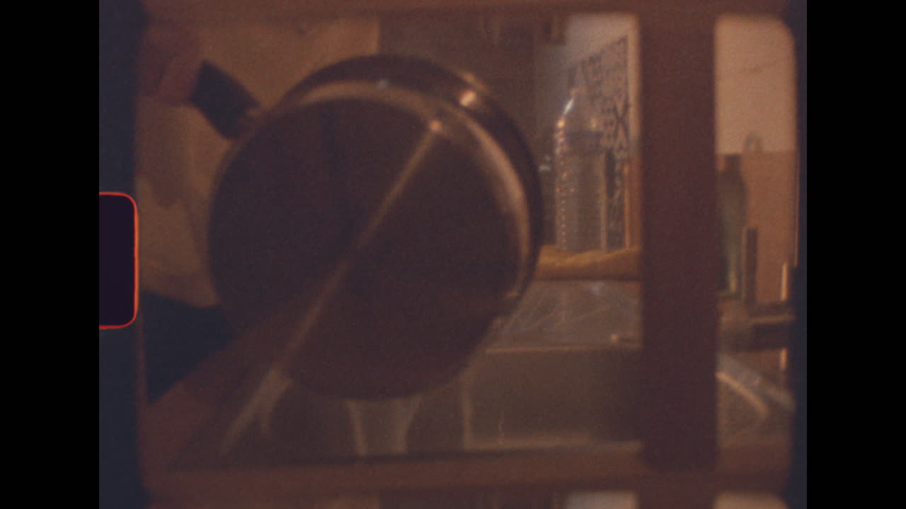 Pouring water into kitchen sink with vintage super 8 film grain