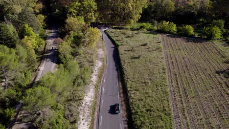 Aerial-tracking-shot-of-a-man-driving-his-classic-car-through-the-French-countryside