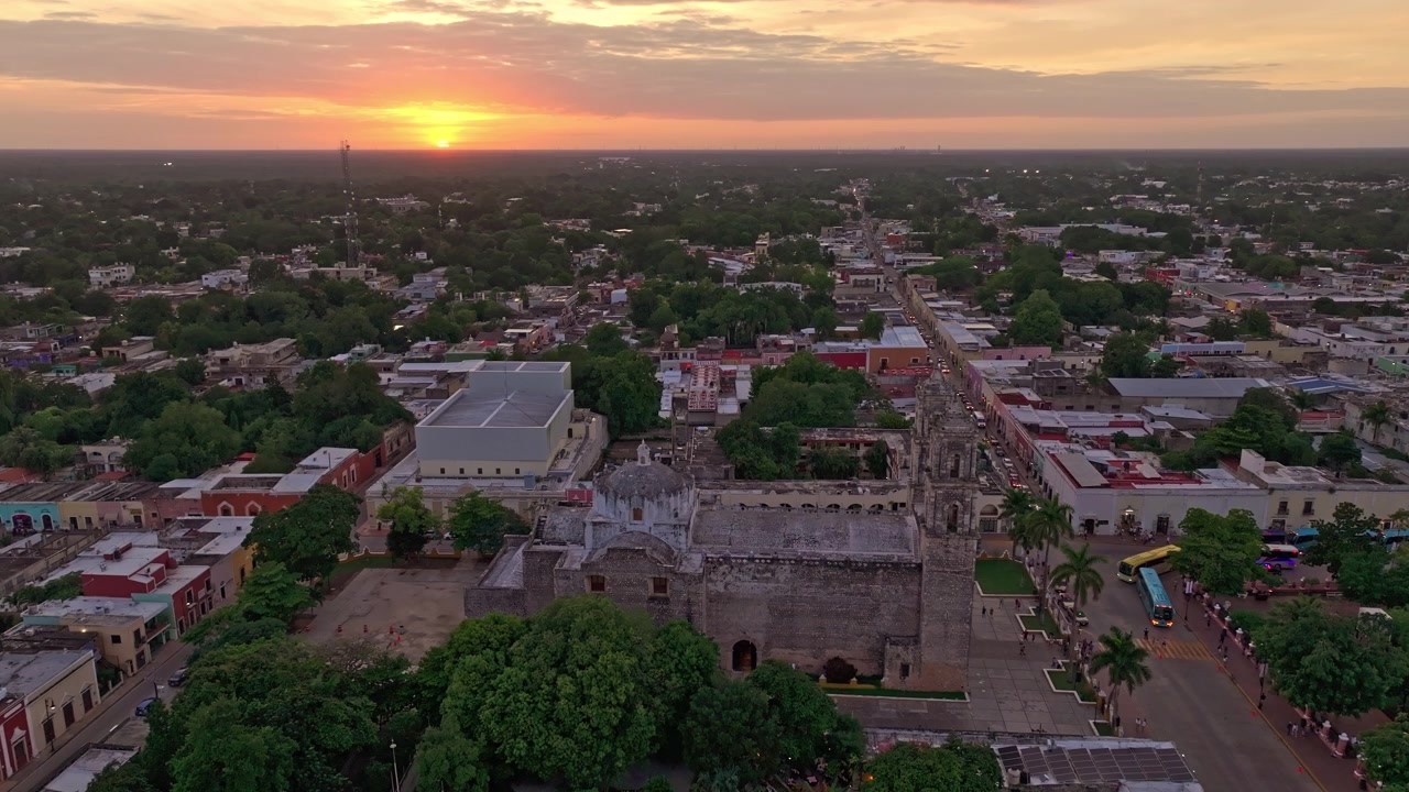 Valladolid, Yucatan, Meksika'nın alçak ufuk çizgisinin havadan görünümü, güneş ufukta batarken ve sömürge kasabasının üzerine sıcak bir ışık düşürürken.