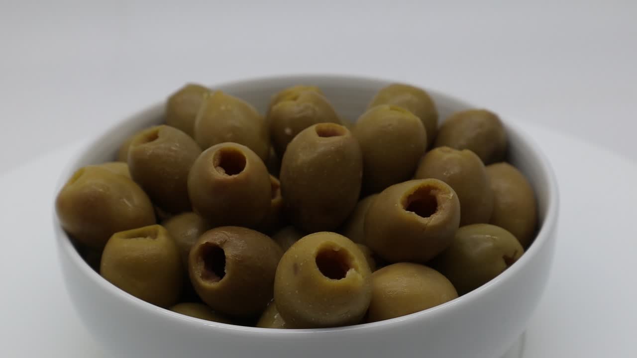 흰색 배경에 격리된 회전 디스플레이에 움푹 패인 녹색 올리브