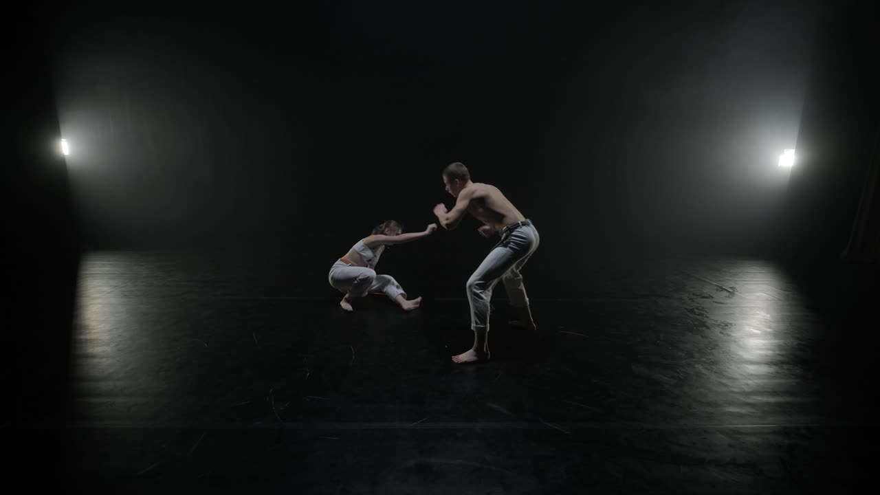 Lottatori di Capoeira che eseguono mosse dinamiche sul palco. Arti marziali, danza e acrobazie in azione. Atleti a torso nudo che mostrano forza, flessibilità e tecnica sotto i riflettori