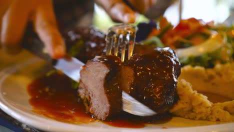 bistec cortado con cuchillo en el plato por una mujer asiática en un restaurante de lujo. concepto de alimentación y dieta saludable.