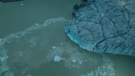 icebergs falling in the water while a glacier is melting due to climate change