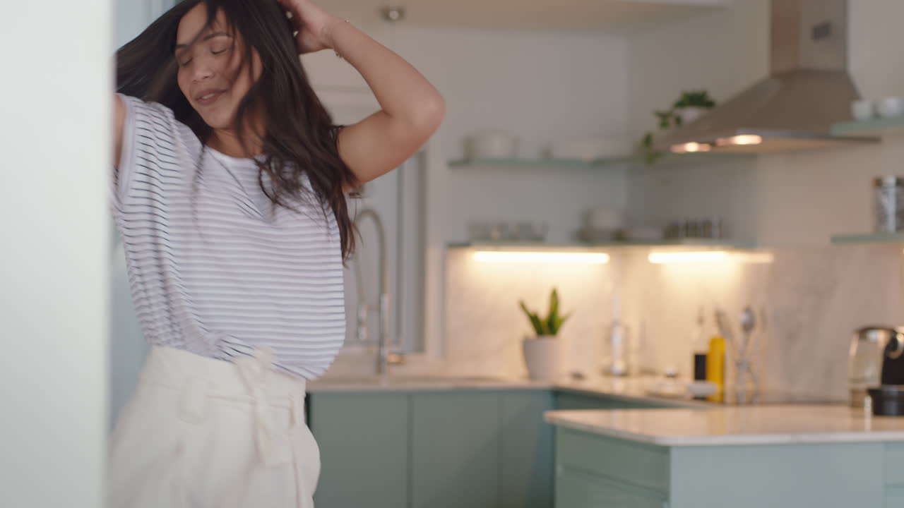 bella donna che balla a casa divertendosi celebrando il successo dello stile di vita godendo di una danza felice nell'appartamento