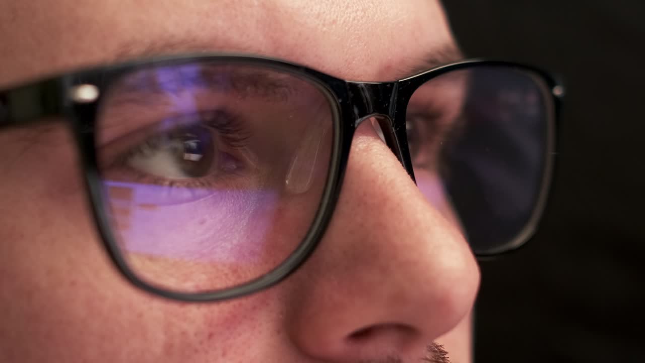 Programmer wears glasses working on computer at office