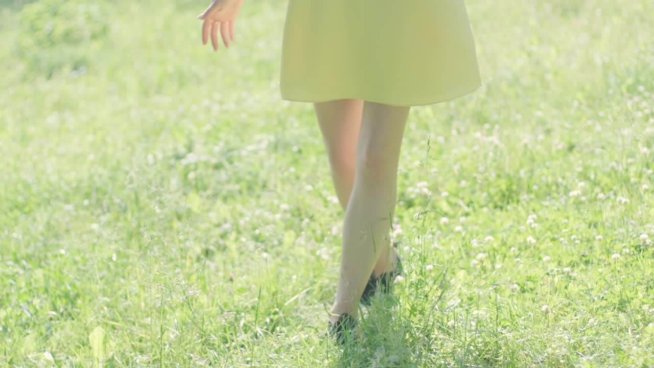 노란색 드레스를 입은 여자가 여름 공원에서 우아하게 춤을 춘다