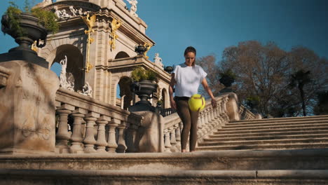 Caucasian-sporty-woman-doing-kick-ups-with-ball-outdoors.