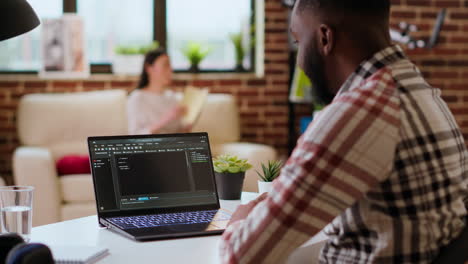 mannelijke programmeur die een app op zijn laptop ontwikkelt en op afstand werkt