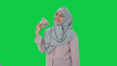 happy muslim businesswoman using money as fan green screen