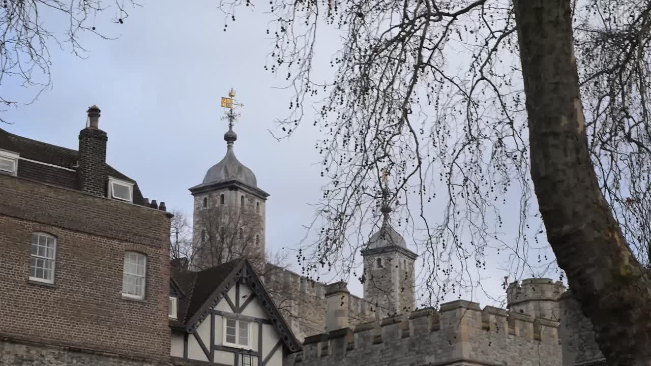 Vista dal basso della facciata della Torre di Londra con forti linee verticali e dettagli in pietra, che enfatizzano l'altezza e l'architettura urbana moderna dal livello della strada.