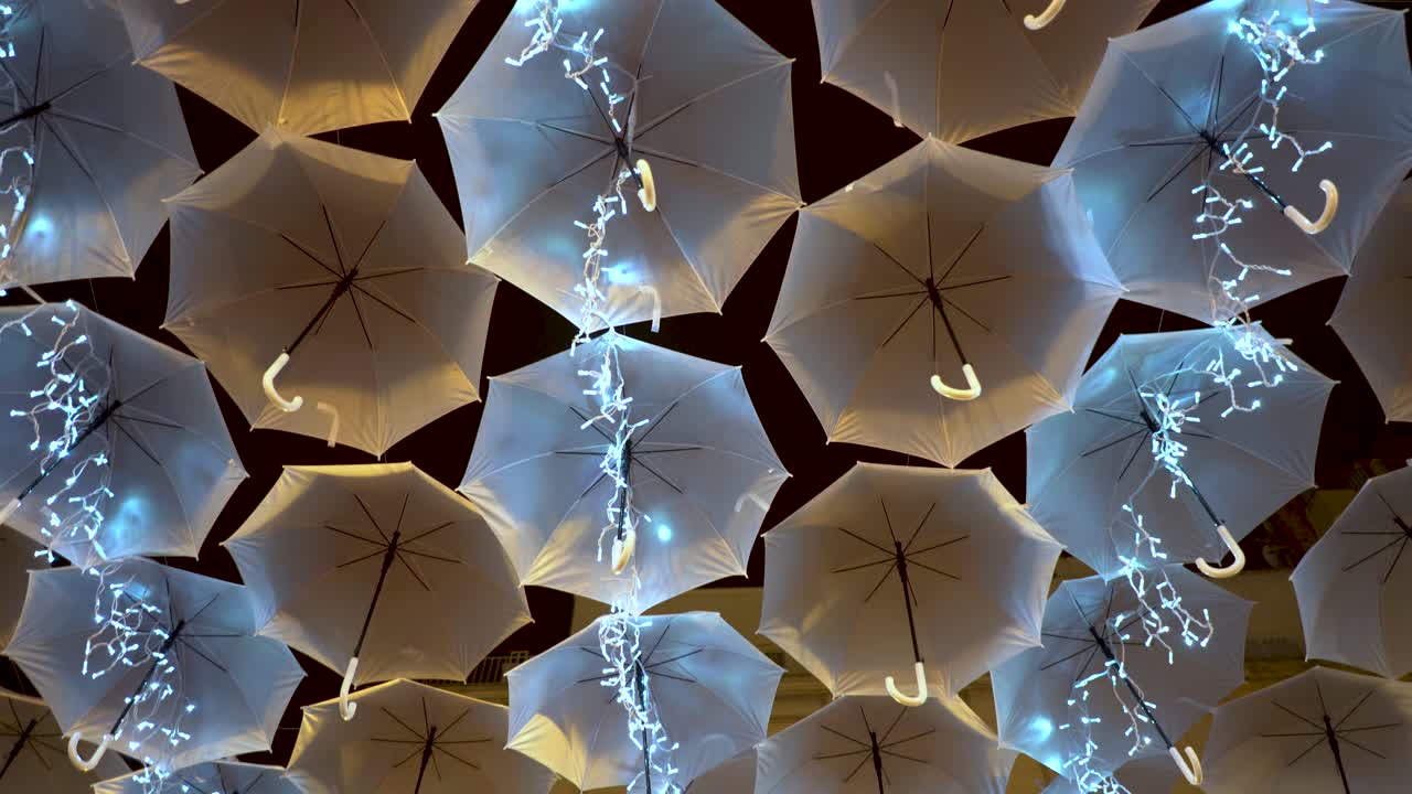 cielo cubierto de sombrillas colgadas adornando las calles y alegrando a la gente, hermosa iluminación, maravillosos detalles en una noche perfecta