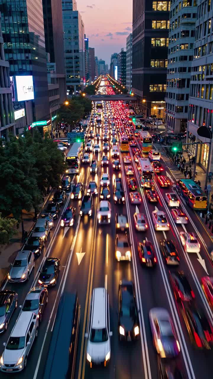 Aerial view of a bustling city street at dusk, showcasing vibrant light trails from cars