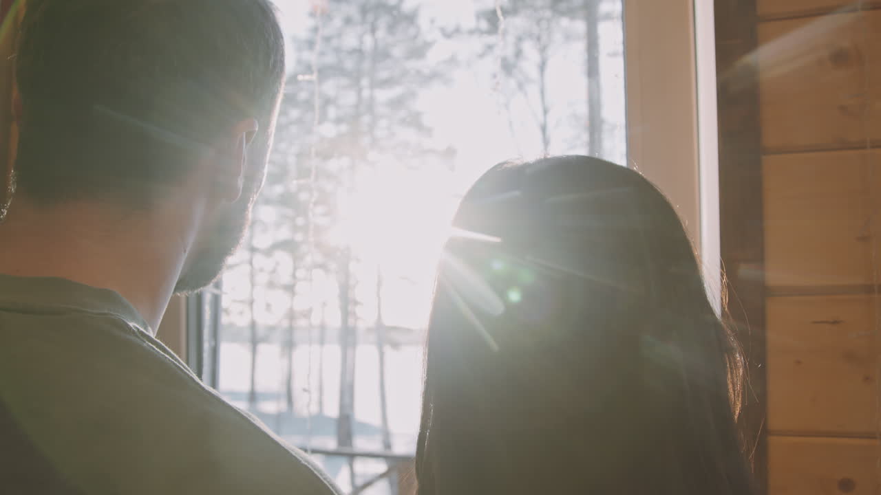Man and Woman Looking Out Window in Cabin