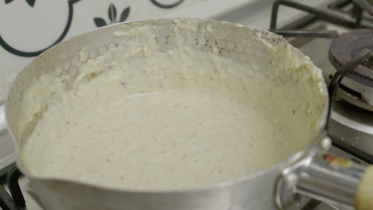 salsa de champiñones mezclada dentro de una olla de metal