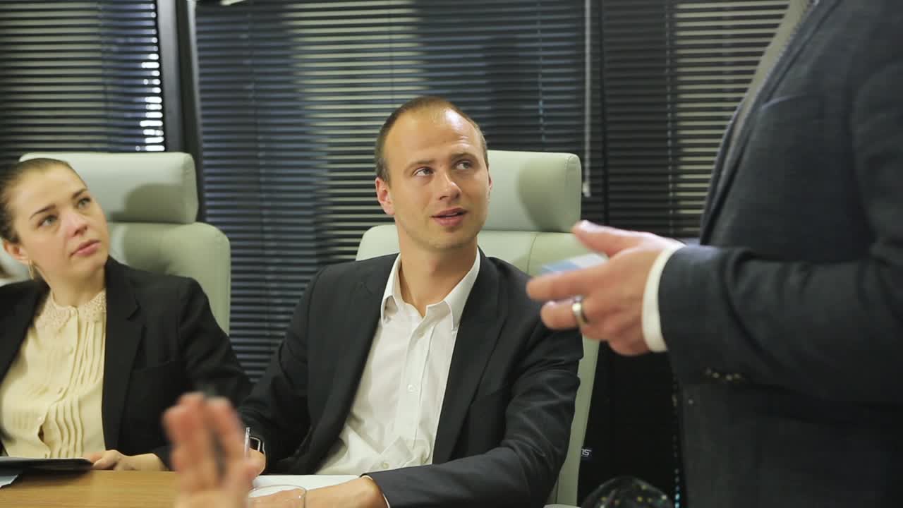 Business Meeting In Office. Business people in formalwear discussing something while sitting together at the table
