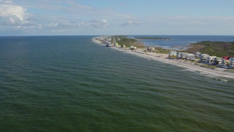 aerial of thin peninsula between gulf of mexico and a bay with homes and roads