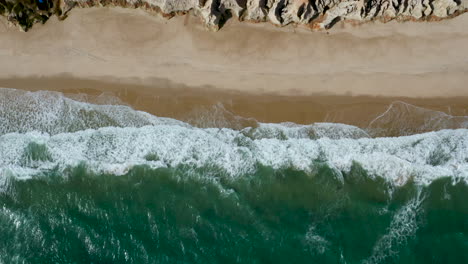 Aerial-view-of-the-sea,-waves-and-the-cliffs-of-Morro-Branco,-Ceara,-Brazil