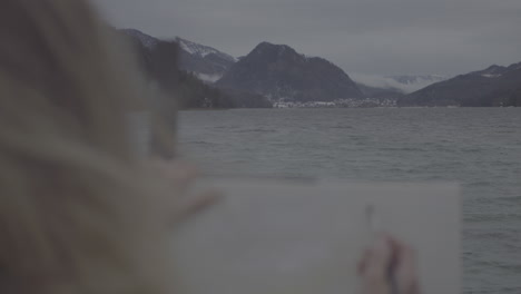 artist painting a winter lakeside landscape