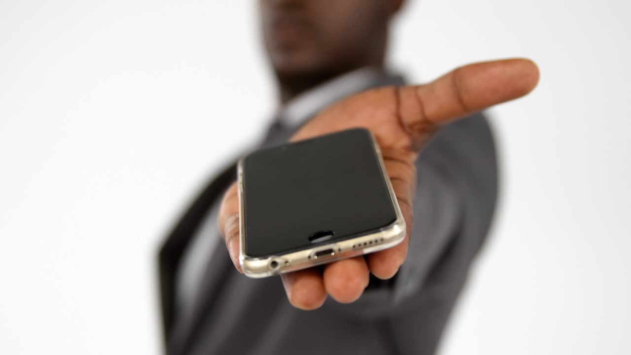 Man in suit offering smartphone, initiating scrolling blue waveforms highlighting tech data