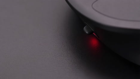 close-up of a computer mouse with a red optical sensor light