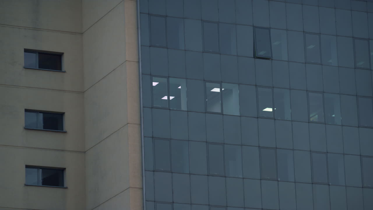 edificio de oficinas de vidrio luz exterior en la habitación drone tiro. inmobiliaria del centro.