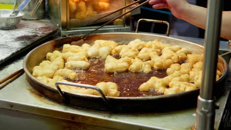 Frying-deep-fried-dough-stick-in-the-pan-at-Yaowarat-Road-Chinatown,-a-popular-travel-destination-in-Bangkok,-Thailand