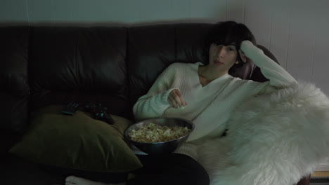 Woman-Eating-Popcorn-And-Watching-TV-At-Home---wide-shot