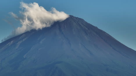 telephoto drone shot in front of mt fujisan and a cloud, summer day in japan