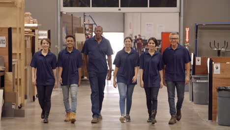 engineers and apprentices walk towards camera in factory