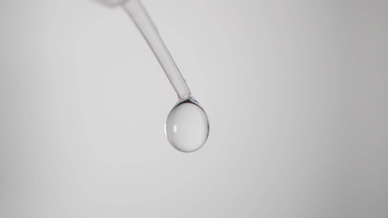 Gocce di fluido dalla punta di una pipetta da laboratorio per il test COVID-19