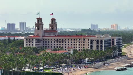 the breakers palm beach resort with beachfront view, surrounded by lush palm trees and iconic twin towers