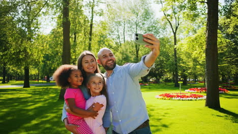 happy family taking a selfie in a sunny park
