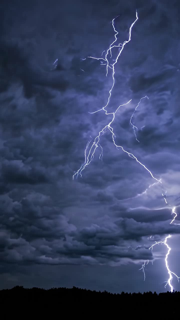 Dramatic low-angle shot of a night sky with vivid lightning striking through dark clouds