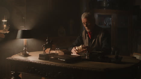 older passionate man evaluates an old porcelain box