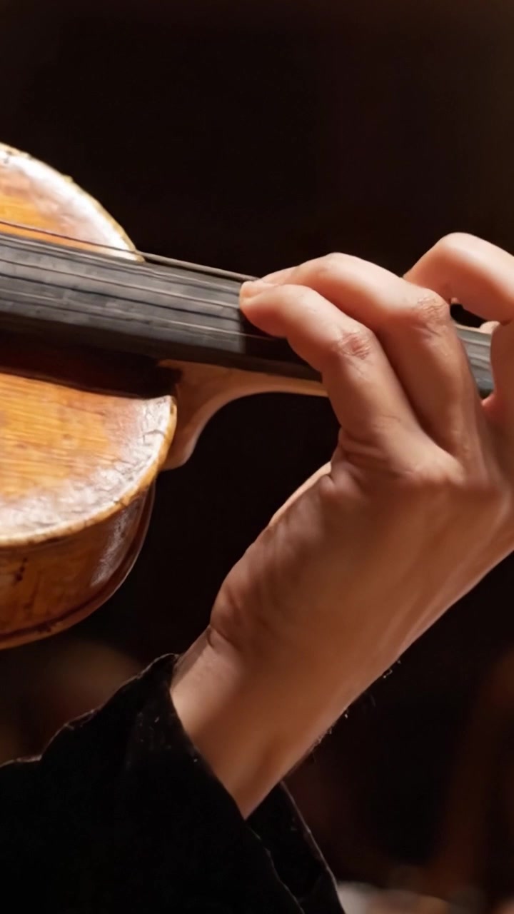 A Close-Up of a Skillful Musician's Hand Gracefully Holding a Violin, Showcasing the Artistry and Precision of Classical Music Performance