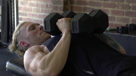 Hombre-Musculoso-En-El-Gimnasio-En-Casa-Haciendo-Ejercicio-De-Prensa-De-Banco-De-Tríceps-Con-Mancuernas-De-Agarre-Estrecho