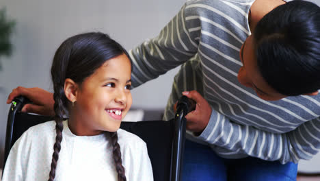 madre interactuando con una niña en silla de ruedas