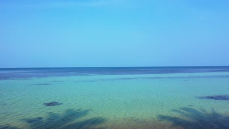 peaceful seascape with clear blue sky over calm lagoon with algae pattern on sea bottom in malaysia, copy space