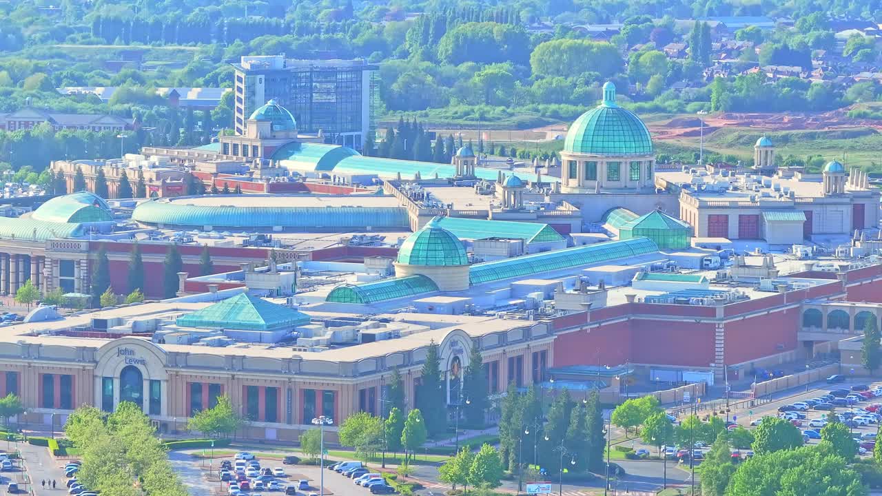 Pan drone shot close to Trafford Centre large indoor shopping centre during the day in Trafford Park, Greater Manchester, England