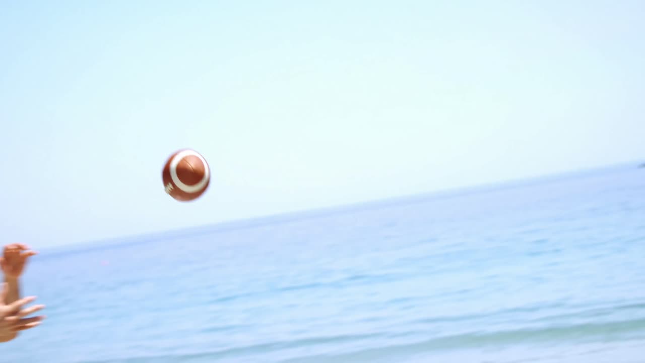 친구 들 이 해변 에서 럭비 를 하고 있다