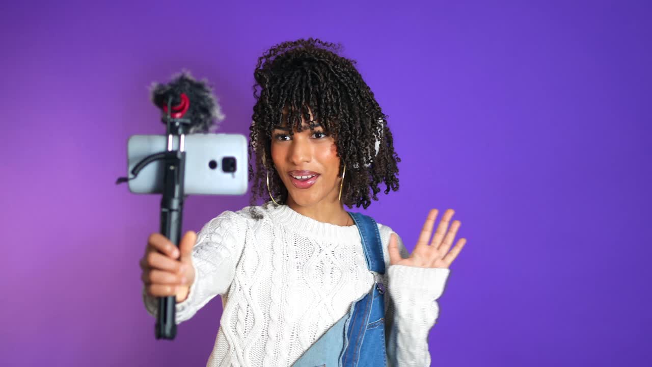Woman Vlogging with Phone on Purple Background